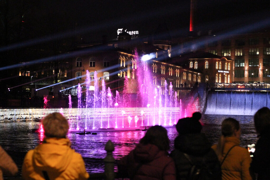 Värivaloin koristeltu vesisuihkuesitys Tammerkoskessa syysiltana.