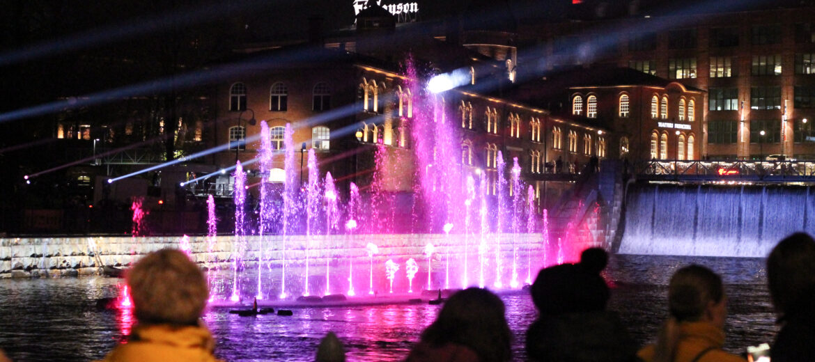 People watching a Dancing Waters foountain show on a autumn evening.